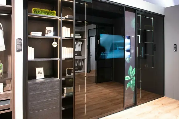 Moderner begehbarer Kleiderschrank mit Glasfront, LED-Beleuchtung und Dekoration.